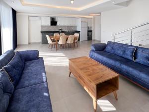 a living room with a blue couch and a table at Vesta Star in Alanya