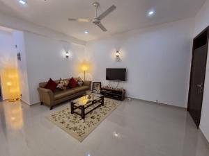 ein Wohnzimmer mit einem Sofa und einem TV in der Unterkunft Pristine residence in Dehiwala