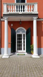 un edificio naranja con columnas blancas y una puerta en B&B Villa Sofora en Reggio Emilia