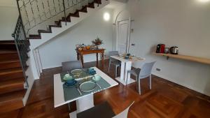 sala de estar con mesa y sillas y escalera en B&B Villa Sofora en Reggio Emilia