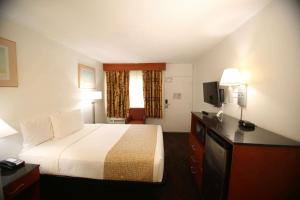 une chambre d'hôtel avec un lit et une télévision dans l'établissement Travelodge by Wyndham Burbank-Glendale, à Burbank