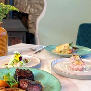 Penybont Restaurant + Inn في كرمرثن: طاولة عليها ثلاثة أطباق من الطعام