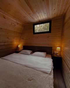 1 dormitorio con 1 cama en una cabaña de madera en Private Cottage in Tbilisi Area - Napetvrebi Hills en Mskhaldidi