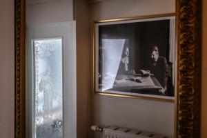 een ingelijste foto van een man aan een tafel in een kamer bij Altstadt Palais in Weimar