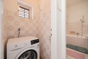 a washing machine in a bathroom with a shower at One bedroom apartment Dragica in Zadar