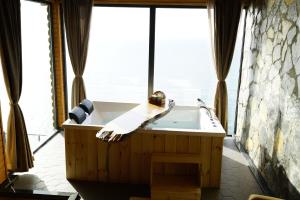 a bathroom with a tub and a large window at Venek Viila Suit in Pazar