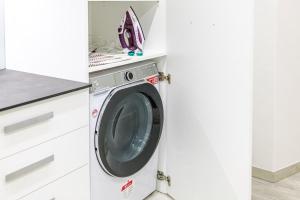 una lavadora y secadora en una cocina blanca en Appartamento San Carlo, en Tirano