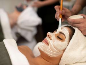 a woman with a mask on her face getting her hair cut at Pullman Magenta Shores Resort in The Entrance