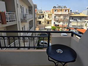 a table on a balcony with a view of buildings at University Apartment in Heraklio