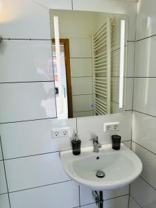 a white sink in a bathroom with a mirror at IBAY in Metzingen