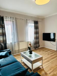 a living room with a blue couch and a table at IBAY in Metzingen