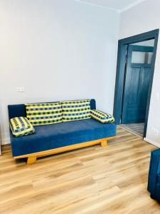 メッツィンゲンにあるIBAYのウッドフロアの客室で、青いソファが備わります。