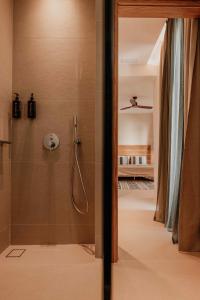 a bathroom with a shower with a glass door at Ostrako Beachside Suites in Agia Anna Naxos
