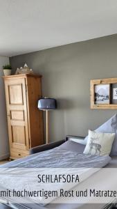 een slaapkamer met een bed en een dressoir met een lamp bij Ferienwohnung Alpenflair mit Pool und Sauna & direkt am Skilift in Missen-Wilhams