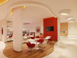 哥印拜陀ibis Coimbatore City Centre - An Accor Brand的一间带桌椅的客厅和一间厨房