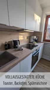 a kitchen with a sink and a counter top at Alpenflair im Ferienpark Oberallgäu- Pool- Sauna- Bikepark- Skilift- Loipe- Wanderwege- stilvoll und kinderfreundlich in Missen-Wilhams