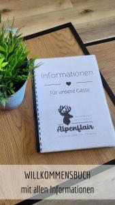 a sign on a table next to a potted plant at Ferienwohnung Alpenflair mit Pool und Sauna & direkt am Skilift in Missen-Wilhams