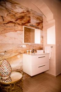 a bathroom with a white vanity and a stone wall at Blue Marine Guest Rooms in Lampedusa