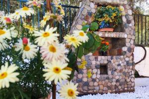 een klein huis met bloemen voor een hek bij Marinos' Place in Skala Kallirakhis