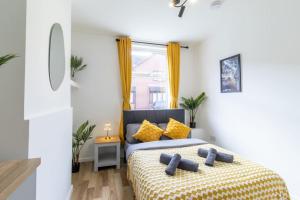 a bedroom with a bed with yellow pillows at Open Mind Property - Luxury 5 Beds & Free Parking in Portsmouth