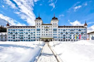 een groot gebouw met sneeuw ervoor bij Grand Hotel des Bains Kempinski in St. Moritz