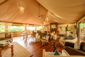 a living room with couches and chairs in a tent at Olare Mara Kempinski in Talek