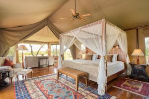 a bedroom with a canopy bed in a tent at Olare Mara Kempinski in Talek