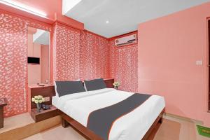 - une chambre avec un grand lit et des murs rouges dans l'établissement Collection O Hotel Raj Palace, à Sātej