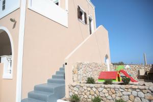 un conjunto de escaleras que conducen a una casa con un tobogán rojo en Anna’s Villa, en Monolithos