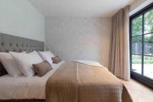 a bedroom with a large bed with a large window at Suite Heiloo in Heiloo
