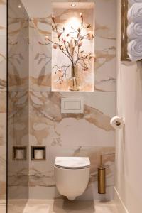a bathroom with a toilet and a vase with flowers at Suite Heiloo in Heiloo