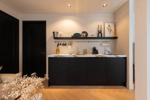 a kitchen with a black counter and a sink at Suite Heiloo in Heiloo
