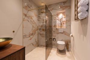 a bathroom with a toilet and a glass shower at Suite Heiloo in Heiloo