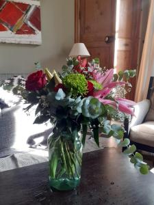a vase filled with flowers sitting on a table at Belle maison, 3 chambres,avec un bassin, un jardin , dans le centre historique in Montpellier