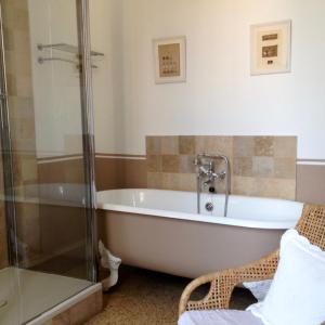 a bath tub in a bathroom with a shower at Belle maison, 3 chambres,avec un bassin, un jardin , dans le centre historique in Montpellier