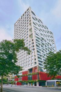 a large white building with red windows on a street at Kempinski Residences Guangzhou - Complimentary Shuttle Bus to Canton Fair Complex & Food Beverage Voucher during Canton Fair period in Guangzhou