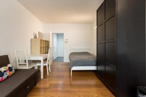 Schlafzimmer mit einem Bett, einem Tisch und einem Schreibtisch in der Unterkunft Appartement à Bruxelles in Brüssel