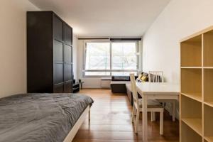 a bedroom with a bed and a table and a desk at Appartement à Bruxelles in Brussels