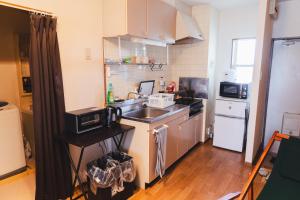 a small kitchen with a sink and a microwave at 寄道アパート高松東インターチェンジ店201 最大5名1戸貸切 無料駐車場 in Kawashima