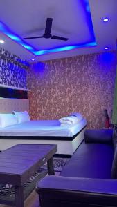 Habitación con cama, mesa y luces púrpuras. en Relax Zone en Patna