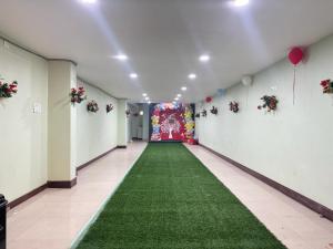 a hallway with a green carpet and a red door at Relax Zone in Patna