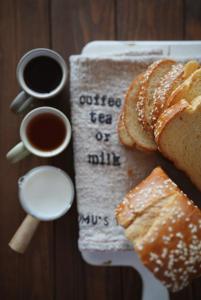 a table with a plate of bread and two cups of coffee at Tranquility Stay in Hanoi