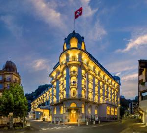 un edificio con una bandiera canadese sopra di esso di Kempinski Palace Engelberg a Engelberg