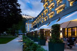 un hôtel avec une rangée de plantes devant un bâtiment dans l'établissement Kempinski Palace Engelberg, à Engelberg