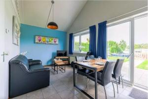 comedor con paredes azules, mesa y sillas en Bungalow de Zwanenbloem, en Wervershoof