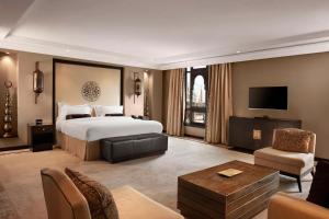 a large hotel room with a bed and a tv at Sofitel Shahd Al Madinah in Al Madinah