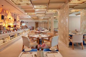 a restaurant with tables and chairs and a bar at Shaza Makkah in Mecca