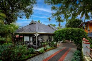 una casa con tetto a foglia d'azzardo e patio di Chalona Hill View a Munnar