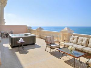 杜拜的住宿－Raffles The Palm，阳台设有热水浴池、沙发和椅子。