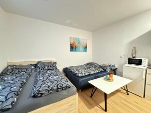 een kleine kamer met 2 bedden en een tafel bij Zrekonstruovaný byt 1kk v centru Liberce in Liberec